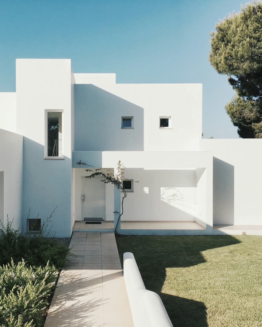 Casa residencial de fachada branca com jardim
